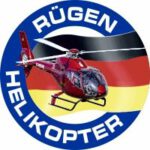 Rundes Logo mit rotem Hubschrauber und Schriftzug „Rügen Helikopter“ vor deutscher Flagge