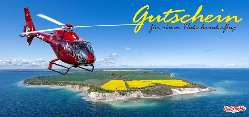 Roter Hubschrauber im Flug über einer malerischen Ostseeinsel mit gelben Rapsfeldern – Gutschein für einen Helikopter-Rundflug
